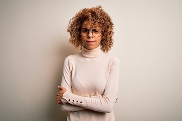 Young african american woman wearing turtleneck sweater and glasses over white background skeptic...
