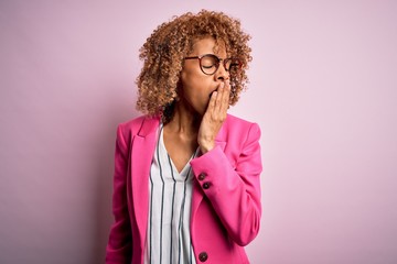 Fototapeta na wymiar Young african american businesswoman wearing glasses standing over pink background bored yawning tired covering mouth with hand. Restless and sleepiness.
