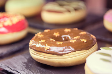 Donuts on stone utensils in a display case.