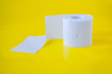 One roll of white toilet paper on a yellow background