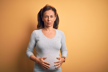 Middle age pregnant woman expecting baby at aged pregnancy with serious expression on face. Simple...
