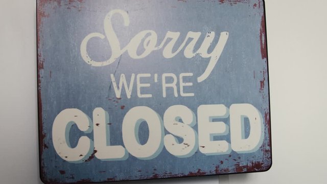 Close up of swinging isolated sorry we're closed sign, Covid-19