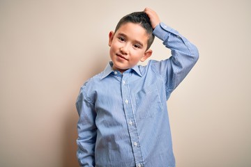 Young little boy kid wearing elegant shirt standing over isolated background confuse and wonder...