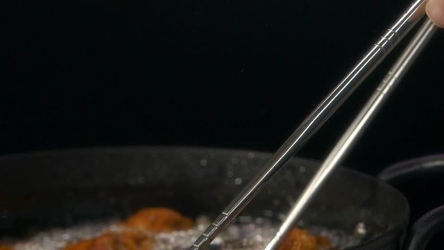 揚げている鶏の唐揚げを油から取り出しているところ