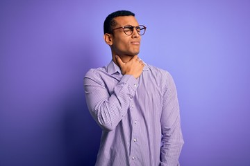 Handsome african american man wearing striped shirt and glasses over purple background Touching painful neck, sore throat for flu, clod and infection