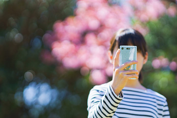 Japanese girl take photo for sharing SNS by using smart phone in Japan