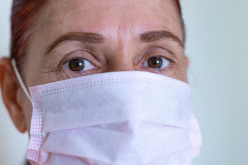Adult woman in the foreground with face mask on white background