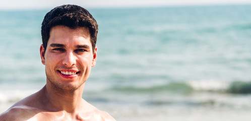 Portrait of smiling happy handsome sexy man showing muscular fit body enjoying and relax standing...