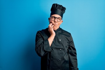Middle age handsome grey-haired chef man wearing cooker uniform and hat touching mouth with hand with painful expression because of toothache or dental illness on teeth. Dentist