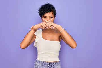 Young beautiful african american afro woman wearing casual t-shirt over purple background Rejection expression crossing fingers doing negative sign