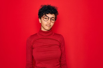 Fototapeta na wymiar Young beautiful african american afro woman wearing turtleneck sweater and glasses looking sleepy and tired, exhausted for fatigue and hangover, lazy eyes in the morning.