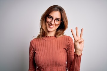 Young beautiful brunette woman wearing casual sweater and glasses over white background showing and...