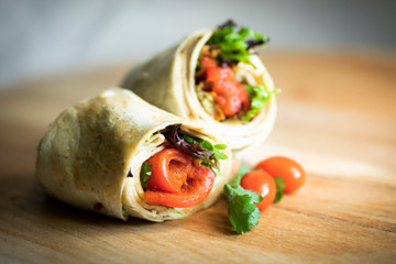 A fresh tasty California turkey wrap displayed on a wooden cutting board