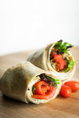 A fresh tasty California turkey wrap displayed on a wooden cutting board