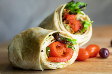 A fresh tasty California turkey wrap displayed on a wooden cutting board