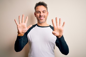 Young handsome man wearing casual t-shirt standing over isolated white background showing and...