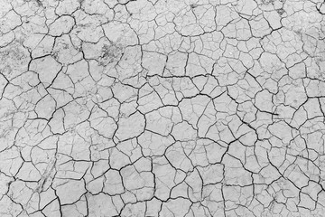Gray dry soil ground cracks background texture in drought, Top view
