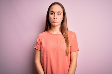 Obraz premium Young beautiful woman wearing casual t-shirt standing over isolated pink background depressed and worry for distress, crying angry and afraid. Sad expression.