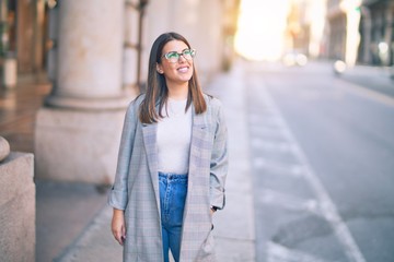 Obraz premium Young beautiful woman smiling happy and confident. Standing with smile on face at the town street