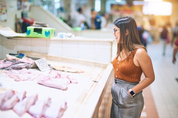 Young beautiful woman smiling happy and confident. Standing with smile on face buying food at supermarket