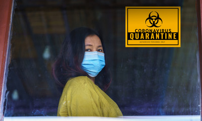 Corona virus concept.  Sick asian woman of corona virus looking through the window and wearing mask...