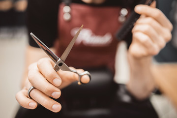 Close-up barber holds clip-on hair clipper barbershop