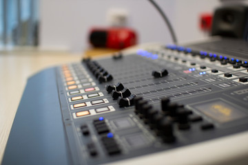 Professional audio mixing console with faders and adjustment knobs.