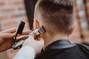 Hairdresser cuts hair men in barbershop. Barber doing correct beard trim electric shaver