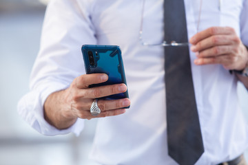 Close up businessman hand using smartphone, business networks concept.