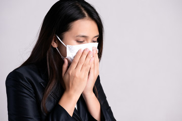 Close up of a businesswoman in a suit wearing Protective face mask and cough, get ready for Coronavirus and pm 2.5 fighting against on gray background.