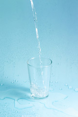 Obraz na płótnie Canvas splashing clean water in glass on pastel background