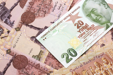 A close up image of a green twenty Turkish lira bank note on a background of Egyptian one pound bank notes in macro