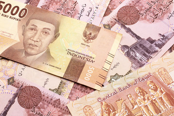 An orange, five thousand Indonesian rupiah bank note with Egyptian one pound bank notes close up in macro