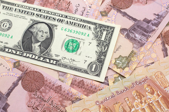 A close up image of a an American one dollar bank note with Egyptian one pound bank notes in macro
