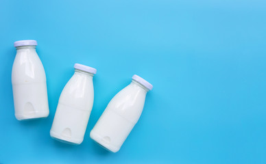 Milk bottles on blue background.