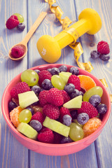 Vintage photo, Fresh fruit salad and centimeter with dumbbells, healthy lifestyle and nutrition...