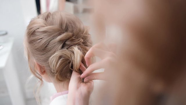Professional woman stylist final touch of hairstyling use bobby pin. Shot with RED camera in 4K