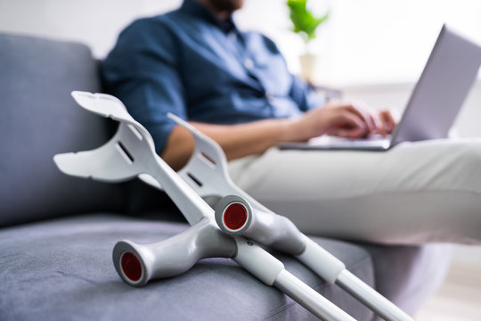 Man With Leg Injury Using Laptop