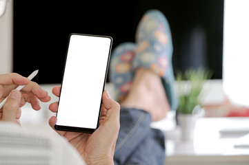 Relaxed man working from home and using smartphone.