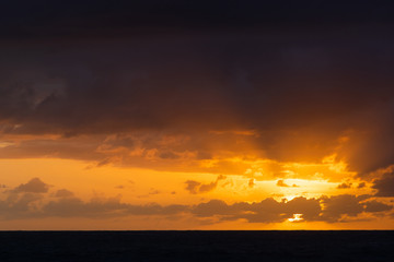 Orange sky view during sunrise with clouds around.