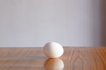 Fototapeta na wymiar Egg on wooden table. Soft sunlight from windows. Table top shot. Front view. Food background. Copy space.