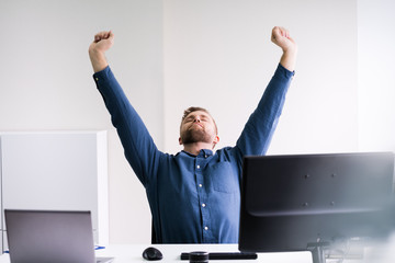 Close-up Of Businessman Stretching His Hands At Workplace