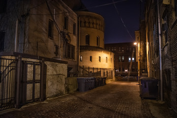 Fototapeta na wymiar Dark and eerie urban city alley at night