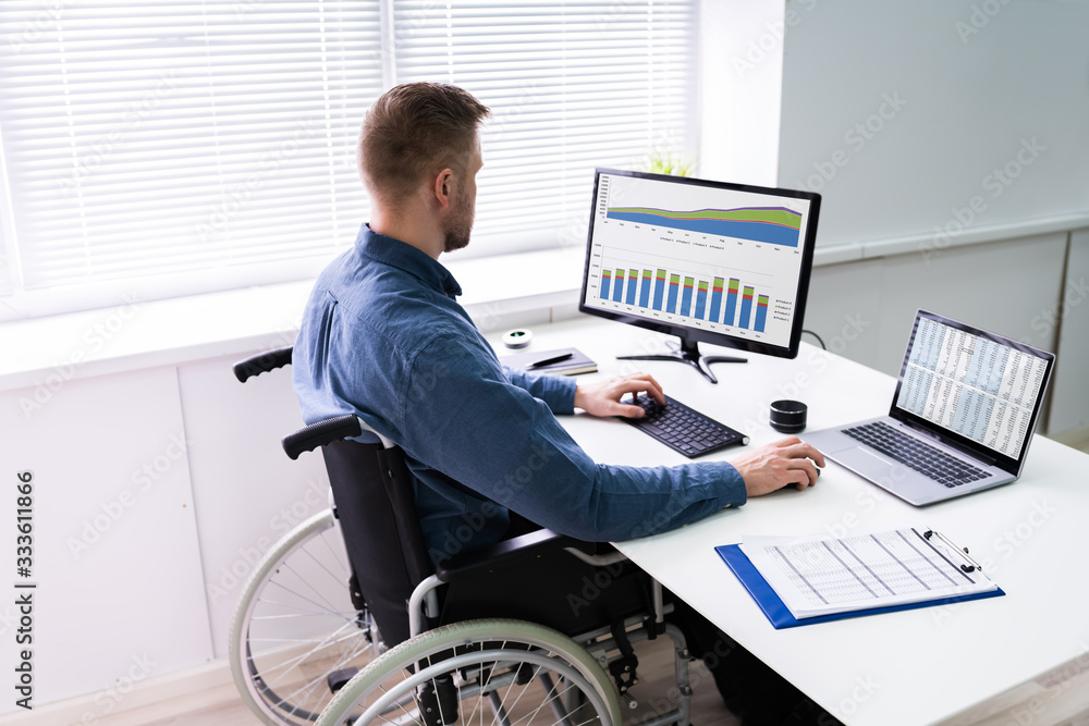 Poster businessman sitting on wheelchair and using computer