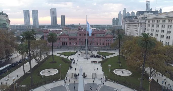 Aerial Drone Scene of May Square and Casa Rosada. The camera travels forward with a flaming flag. Landscape of the pyramid and pink house, historic building. Buenos Aires, Argentina
