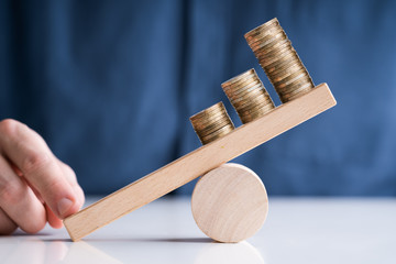 Businessperson Balancing Increasing Stacked Coins With Finger