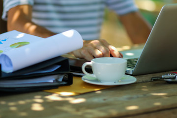Young asian man working online from home at the garden. Man using laptop for online working at home.