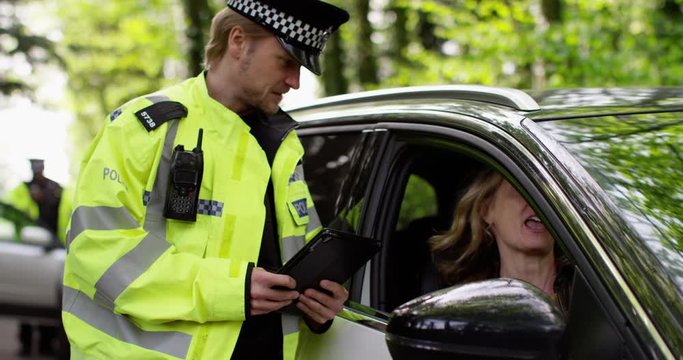 4K Argumentative woman in car giving bad attitude to policeman about traffic offence. Slow motion.