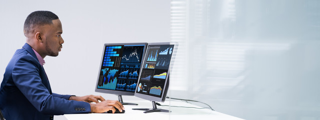 Stock Market Broker Analyzing Graphs On Laptop