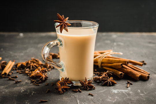 Tasty tea mith milk and spices on the rustic background. Selective focus. Shallow depth of field.